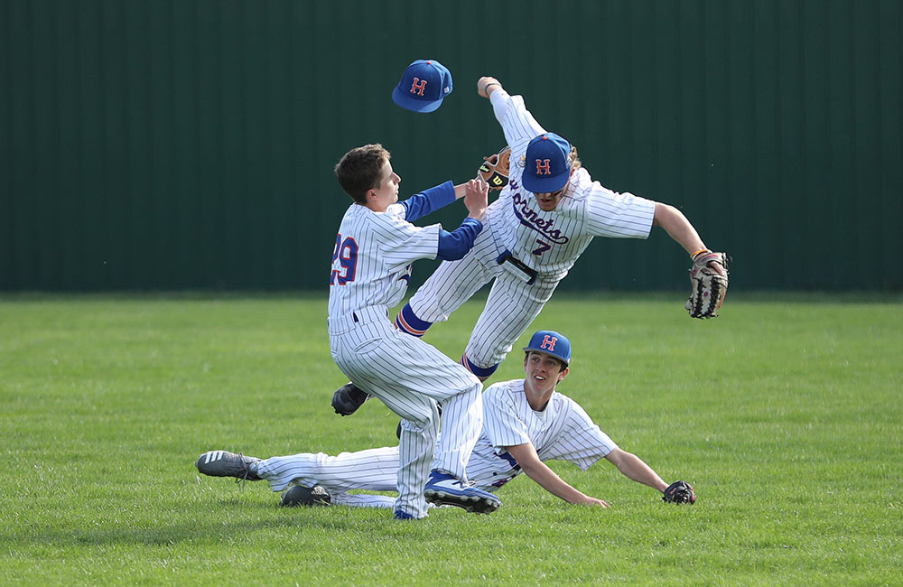 Hillcrest High School baseball players collide in the outfield during a Spring 2021 home game against Waynesville.