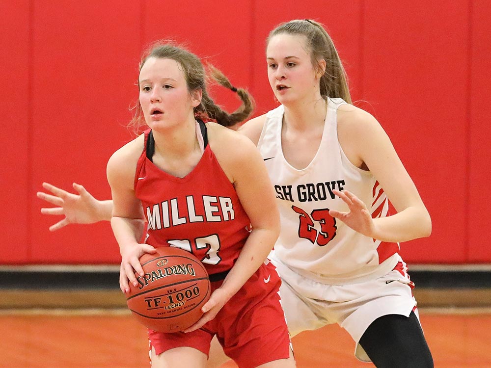 An Ash Grove defender challenges a Miller player for possession of the basketball in a Southwest Conference game on February 5, 2021, in Ash Grove, Missouri.