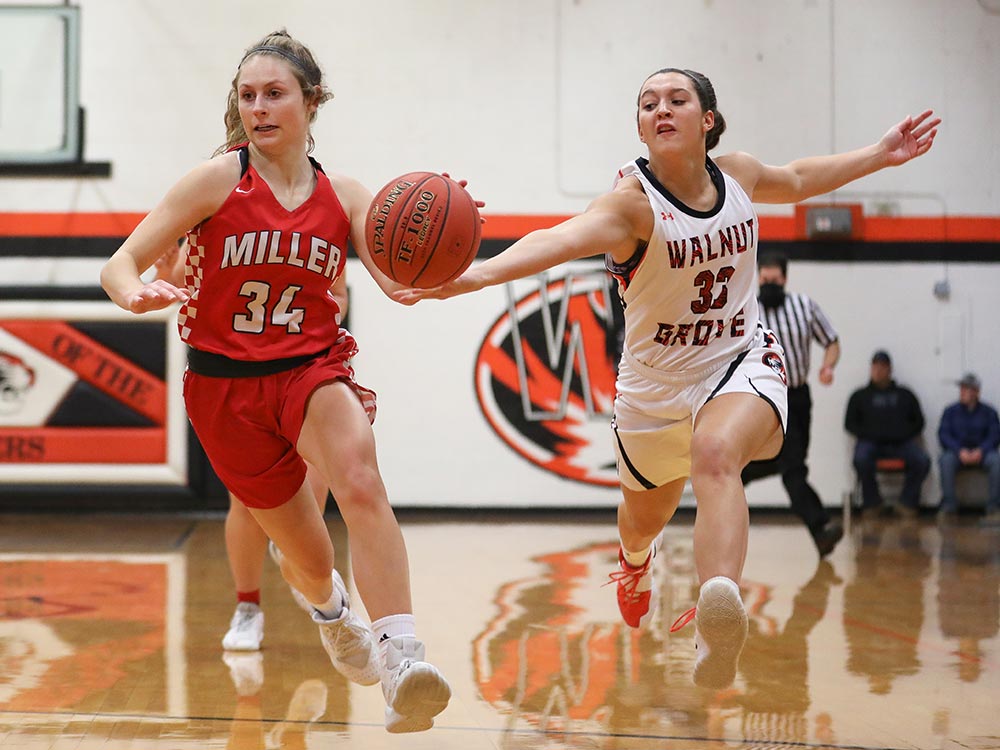 A player from Miller High School avoids the challenge of a Walnut Grove player during a basketbal game on December 30, 2020.