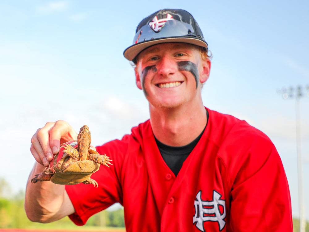 An Aurora High School baseball player poses for a photo with Sosa, the team's newly adopted mascot.
