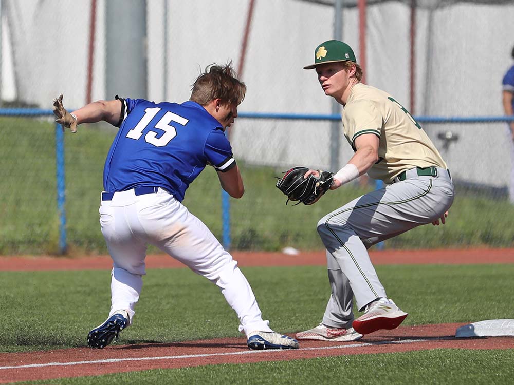 A Hollister baseball player looks to avoid the tag of a Lafayette (St. Joseph) player in the Class 4 third-place game.